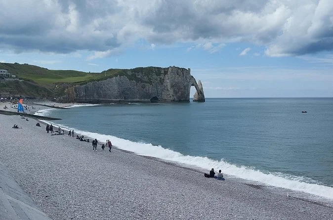Der Kieselstrand und der Aval-Bogen unter einem schweren grauen Himmel