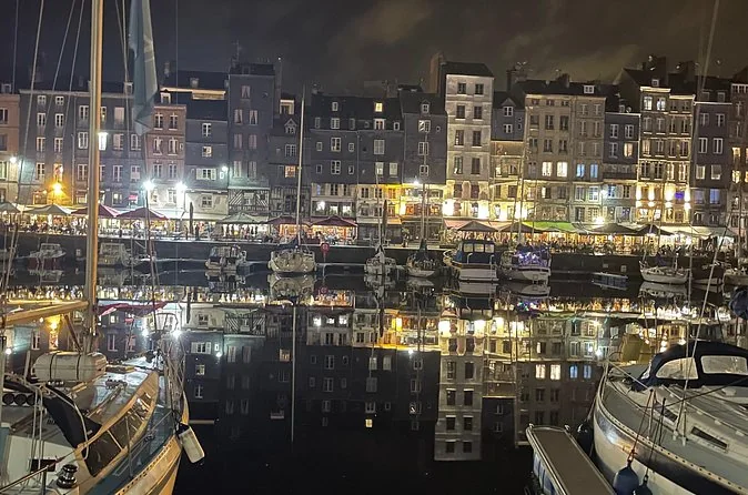 Honfleur's harbour at night with lit houses reflected in the water